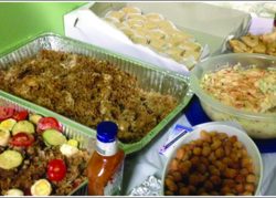 Traditional Mediterranean food spreads across a table for the gathered members of the community.