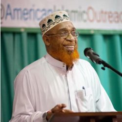 handsome African American man smiles as he speaks during a Dawah conference