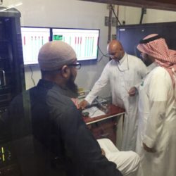 Control Room with three men implementing the Muslim American invention which will provide automatic translation services to people in Mecca.