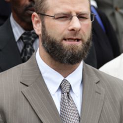 Imam W. D. Mohammed shakes hands with Pope John Paul II and holds his arm while speaking to the pontiff.