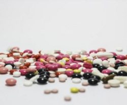 Several different colors of prescription pills are spilled.