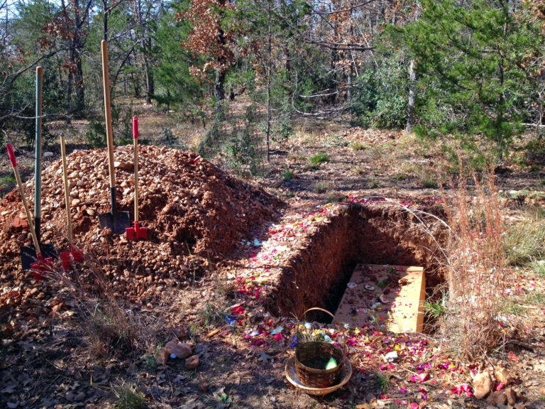 A Green Burial shown here with a natural forest setting and a simple pine box coffin which will break down over time.